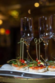 A luxurious catering table is adorned with champagne glasses and delectable appetizers, creating an opulent atmosphere for a special event.