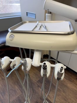 Denver, Colorado, USA-February 17, 2024- Essential tools of a dental workstation, featuring a traditional spit sink and an array of handpieces. The setup is indicative of a professional dental environment.