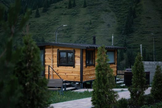 Wooden sauna in summer at the house with a mountain landscape in the background.