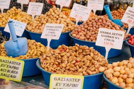 Different olives sale in the traditional farm Turkish market, a counter filled with fresh fruits