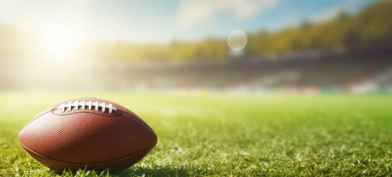 Close-up of an American football on bright green grass in the sunlight, representing sports and outdoor activities.