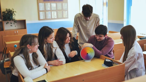 Students in physics class spin Newton's colorful wheel