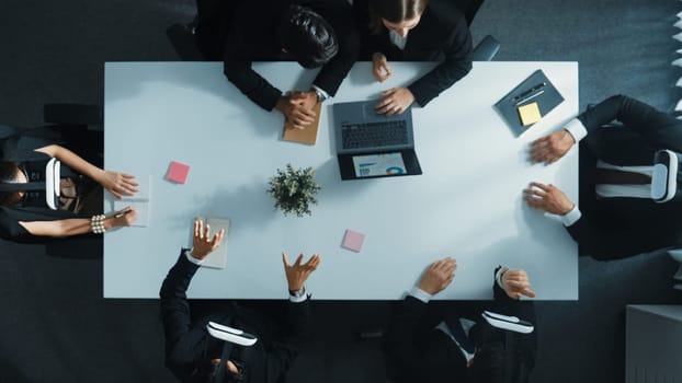 Top view of smart manager give vr head set to businesspeople while businesswoman prepare data analysis or analytic graph in laptop at meeting. Startup team preparing to enter meta verse. Directorate.