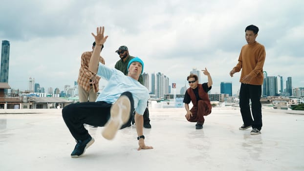 Professional break dance team practice B-boy dance while multicultural friends at rooftop. Young modern dancing group doing hip hop movement. Style,fashion,action. Outdoor sport 2024. Endeavor.