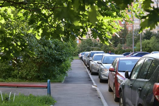 Moscow, Russia - 11 June 2023. Row of cars parked along sidewalk near house