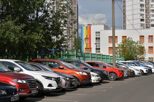 Moscow, Russia - 07 July 2023. Row of cars parked along sidewalk near house