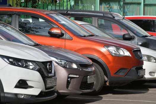 Moscow, Russia - 07 July 2023. Row of cars parked along sidewalk near house