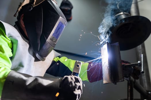 Industry worker welding a pieces of metal in a factory, weld concept