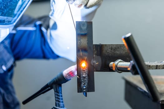 Welder worker welding pieces of metal in the industrial factory, heavy weld industry concept