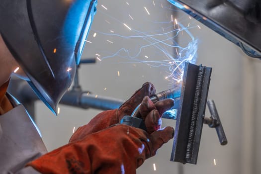 Welder man welding a metal, using the blowtorch, electric arc, or other means, and uniting them by pressing, heavy industrial concept