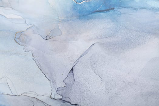 Blue and gold alcohol ink. Style incorporates the swirls of marble or the ripples of agate. Abstract painting, trendy background for wallpapers, posters, cards, invitations, websites.