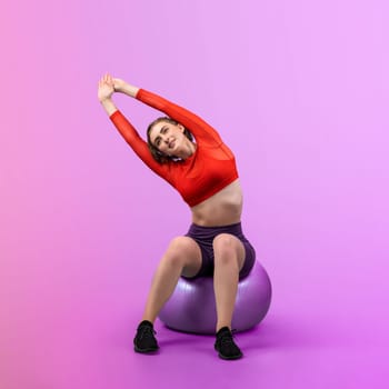 Full body length gaiety shot athletic and sporty young woman with fitness exercising ball in standing posture on isolated background. Healthy active and body care lifestyle.