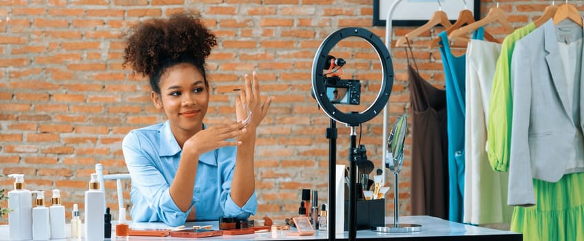 Woman influencer shoot live streaming vlog video review makeup crucial social media or blog. Happy young girl with cosmetics studio lighting for marketing recording session broadcasting online.