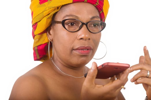 mature woman in glasses standing on white background communicating on cellphone.