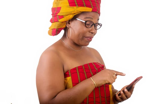 mature woman in traditional dress standing on white background looking at cell phone.