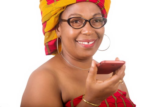 mature woman in traditional dress standing on white background communicating on mobile phone and looking at camera smiling.