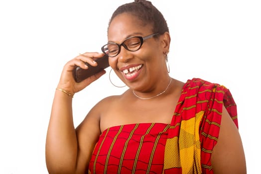 mature woman in traditional dress standing on white background communicating on cell phone laughing.
