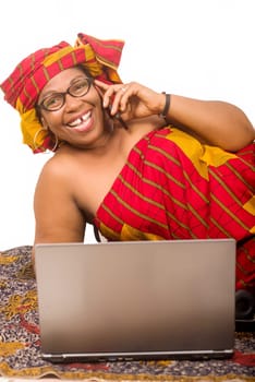 mature woman on white background communicating on cellphone and looking at camera laughing.