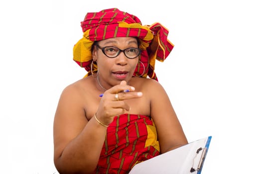 mature woman in loincloth sitting on white background looking at camera while talking with pad notes in hand.