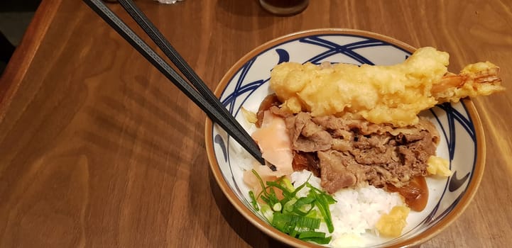 Japanese traditional food beef teriyaki with stickt rice and tempura shrimp sliced spring onion in a bowl
