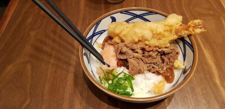 Japanese traditional food beef teriyaki with stickt rice and tempura shrimp sliced spring onion in a bowl