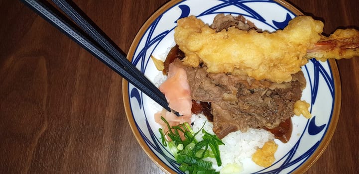 Japanese traditional food beef teriyaki with stickt rice and tempura shrimp sliced spring onion in a bowl