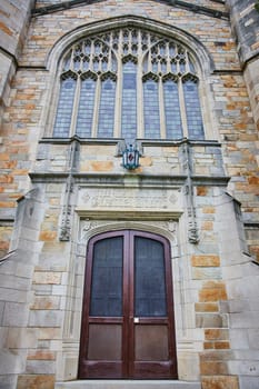 Gothic architecture at University of Michigan Law Quadrangle, featuring grand wooden double doors and intricate stone window