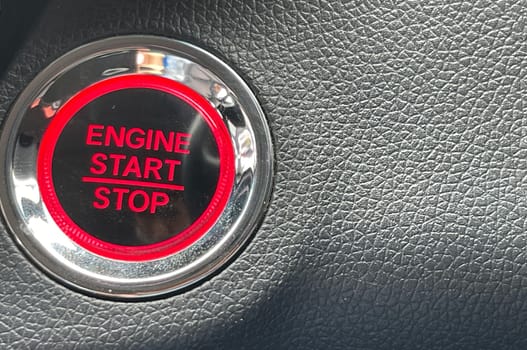 car engine start stop button on dark leather background. copy space Engine Start Button on my car