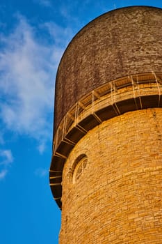 Historic Ypsilanti Water Tower in Michigan, bathed in golden hour sunlight, showcasing timeless architecture against clear blue sky.