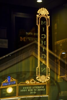 Brightly lit Michigan Theater sign illuminates the night in downtown Ann Arbor, reflecting city life in vibrant LED light.