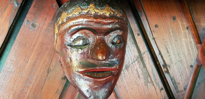 Mystical wooden mask and artworks in traditional retro Javanese style contains spirit of the dead