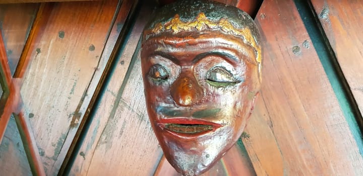 Mystical wooden mask and artworks in traditional retro Javanese style contains spirit of the dead