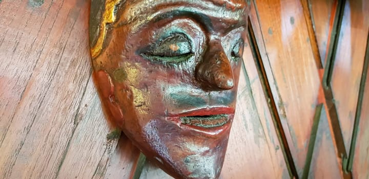 Mystical wooden mask and artworks in traditional retro Javanese style contains spirit of the dead