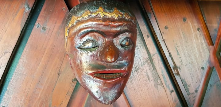 Mystical wooden mask and artworks in traditional retro Javanese style contains spirit of the dead