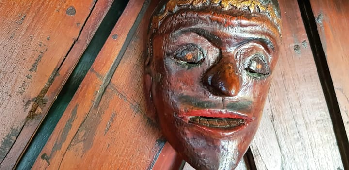Mystical wooden mask and artworks in traditional retro Javanese style contains spirit of the dead
