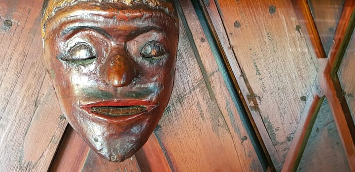 Mystical wooden mask and artworks in traditional retro Javanese style contains spirit of the dead