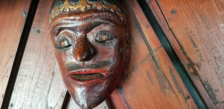 Mystical wooden mask and artworks in traditional retro Javanese style contains spirit of the dead