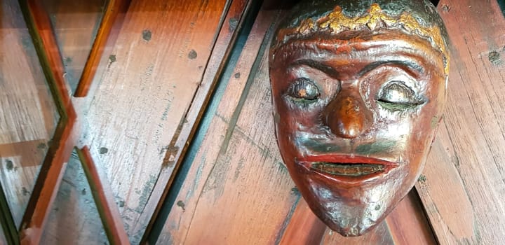 Mystical wooden mask and artworks in traditional retro Javanese style contains spirit of the dead