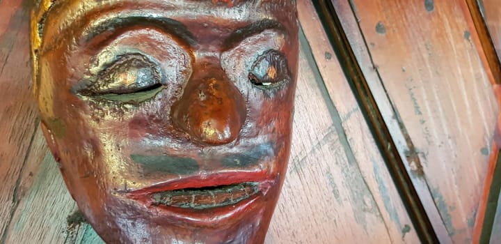 Mystical wooden mask and artworks in traditional retro Javanese style contains spirit of the dead