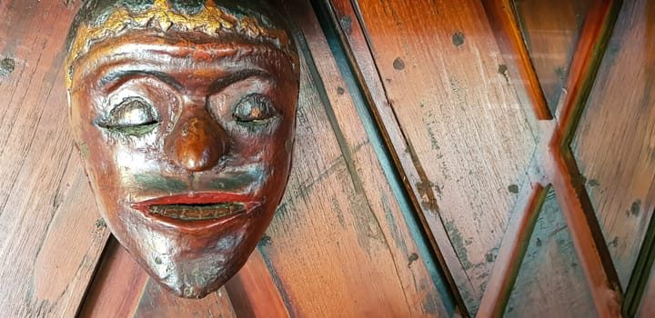 Mystical wooden mask and artworks in traditional retro Javanese style contains spirit of the dead