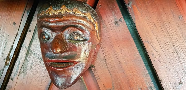Mystical wooden mask and artworks in traditional retro Javanese style contains spirit of the dead