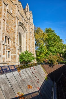 Gothic architecture of University of Michigan Law Quadrangle framed by autumn ivy and green foliage, Ann Arbor