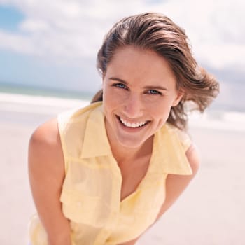 Happy woman, portrait and beach for summer holiday, weekend or tropical vacation in nature. Face of young female person with smile and yellow dress for fun travel or enjoying outdoor day by the ocean.