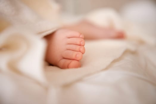 Baby, feet and toes or blanket as closeup for childhood development or nursery sleeping, relax or resting. Kid, wellness and childcare on bed for wellbeing nap or dreaming nurture, caring or calm.