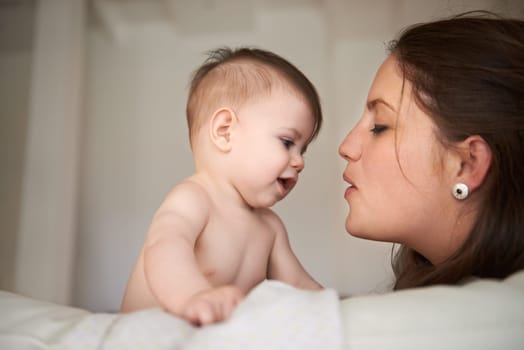 Mother, baby and love connection in home with parenting bonding on bed for childhood development, support or safety. Kid, female person and together for young nurture or nursery, relax or security.