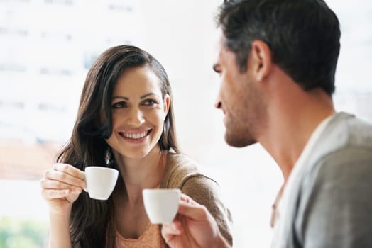 Happy, conversation and couple with coffee on date for romance or anniversary in cafeteria. Love, bonding and young man and woman talking and drinking latte, espresso or cappuccino at restaurant