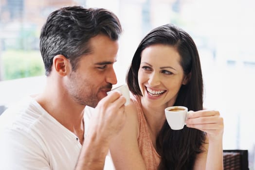 Happy, discussion and couple with coffee on date for romance or anniversary in cafeteria. Love, bonding and young man and woman talking and drinking latte, espresso or cappuccino at restaurant