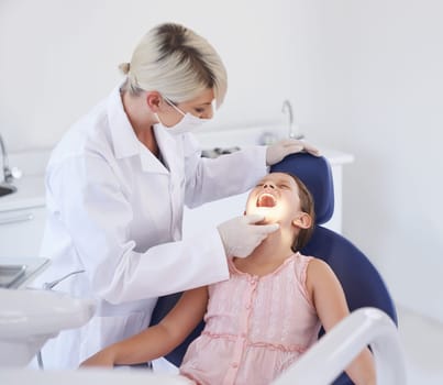 Girl, child and dentist with consultation for healthcare, gum disease and dental hygiene with mouth inspection. Medical, orthodontics and professional for teeth health, cleaning or open with wellness.