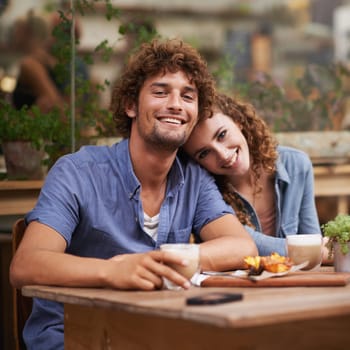 Smile, love and portrait of couple at coffee shop on romantic, anniversary or morning date. Happy, positive and young man and woman bonding at cafeteria or restaurant for cappuccino together