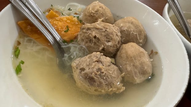 super delicious, tender and juicy and spicy bites of beef tendon meatballs in a bowl in Indonesian street food